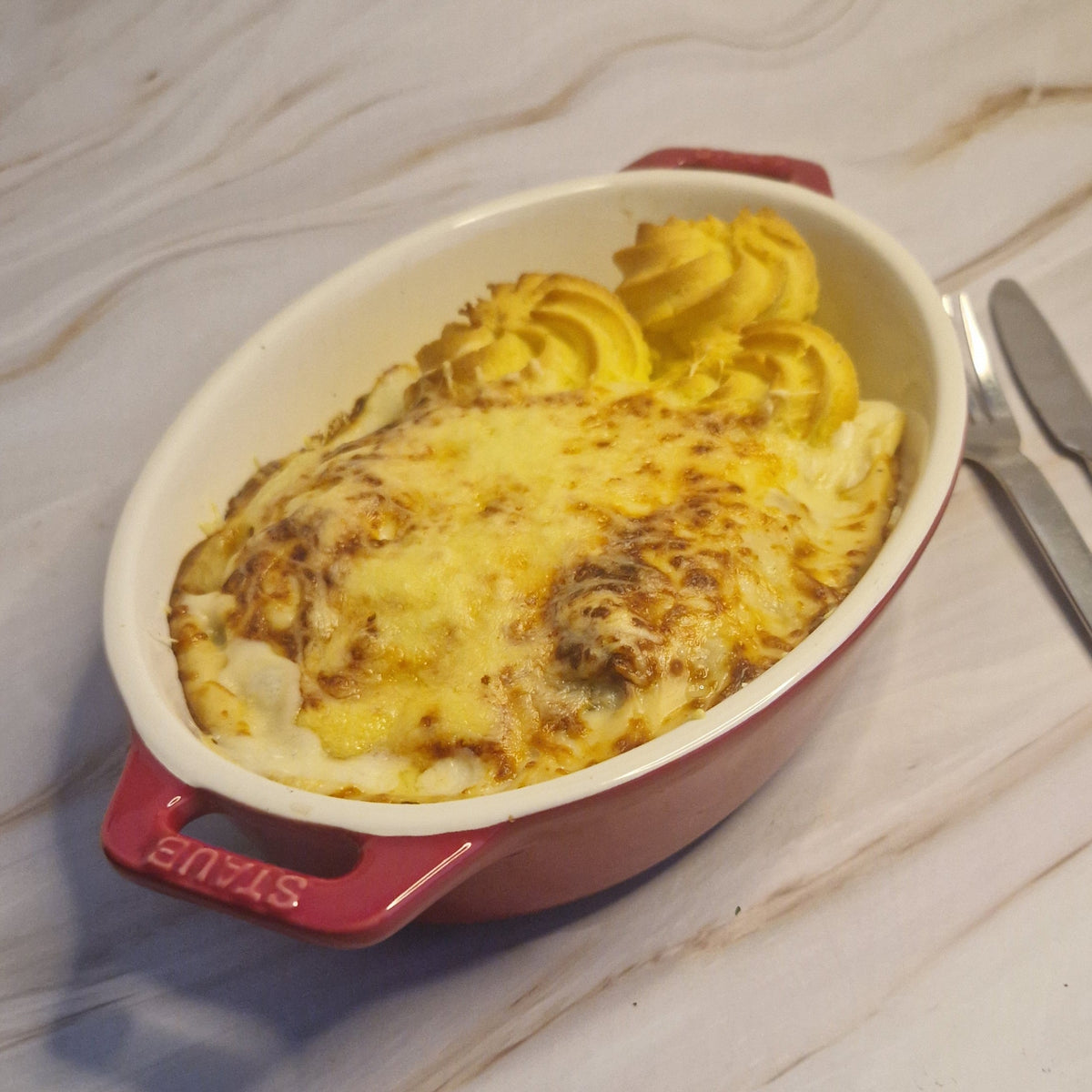 Gegratineerd witloof met gerookte zalm, duchesseaardappel & Nantuasaus