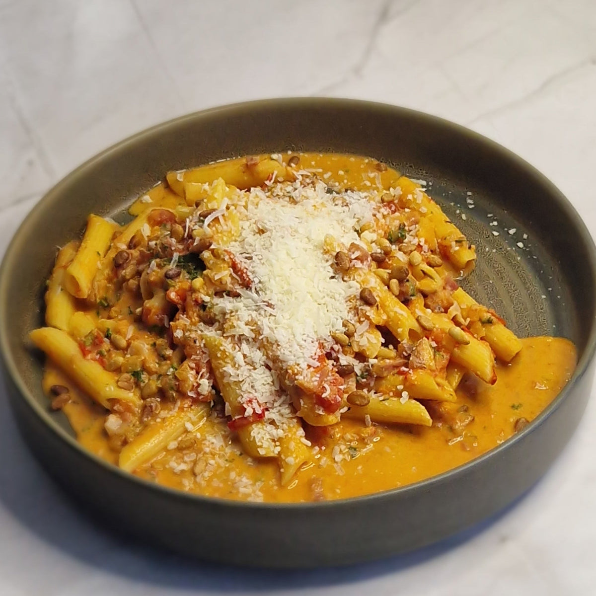 Pasta all’Amatriciana met spek, tomatensaus en Parmezaan van Arno’s to go in Beveren